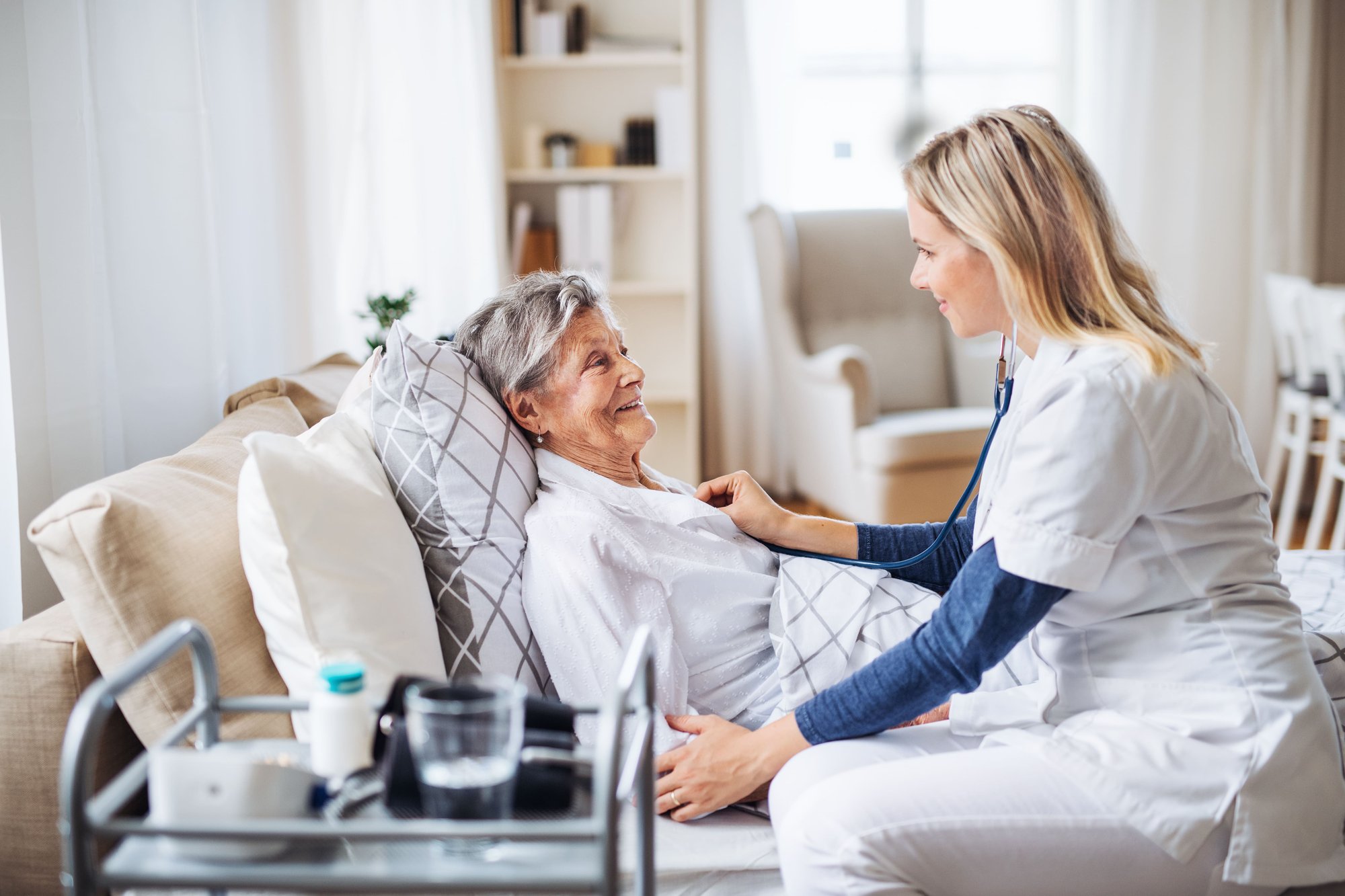 Woman tending to patient in bed