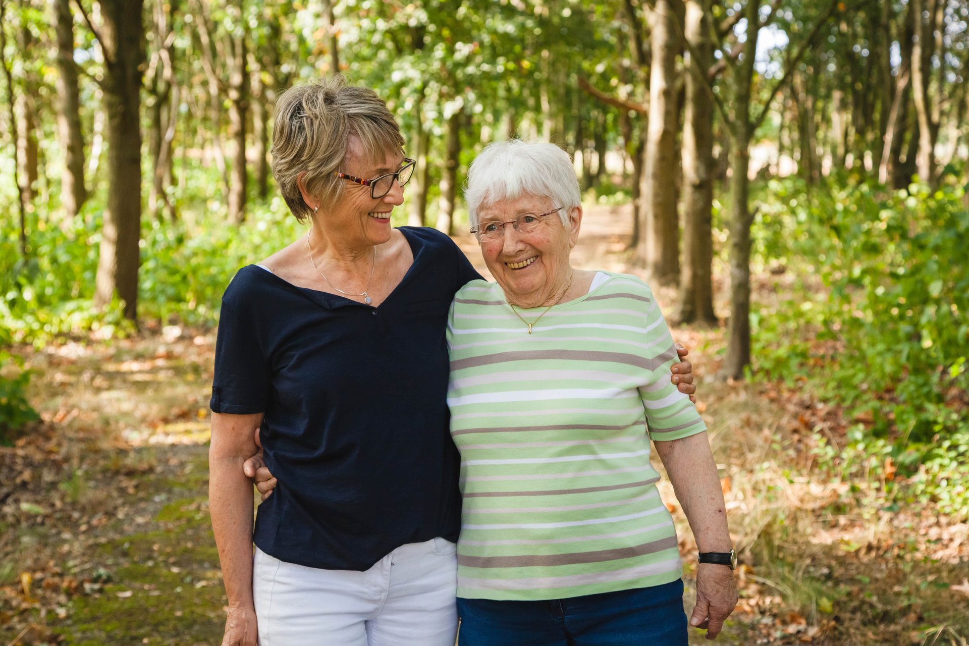 daughter and mother walking through the woods