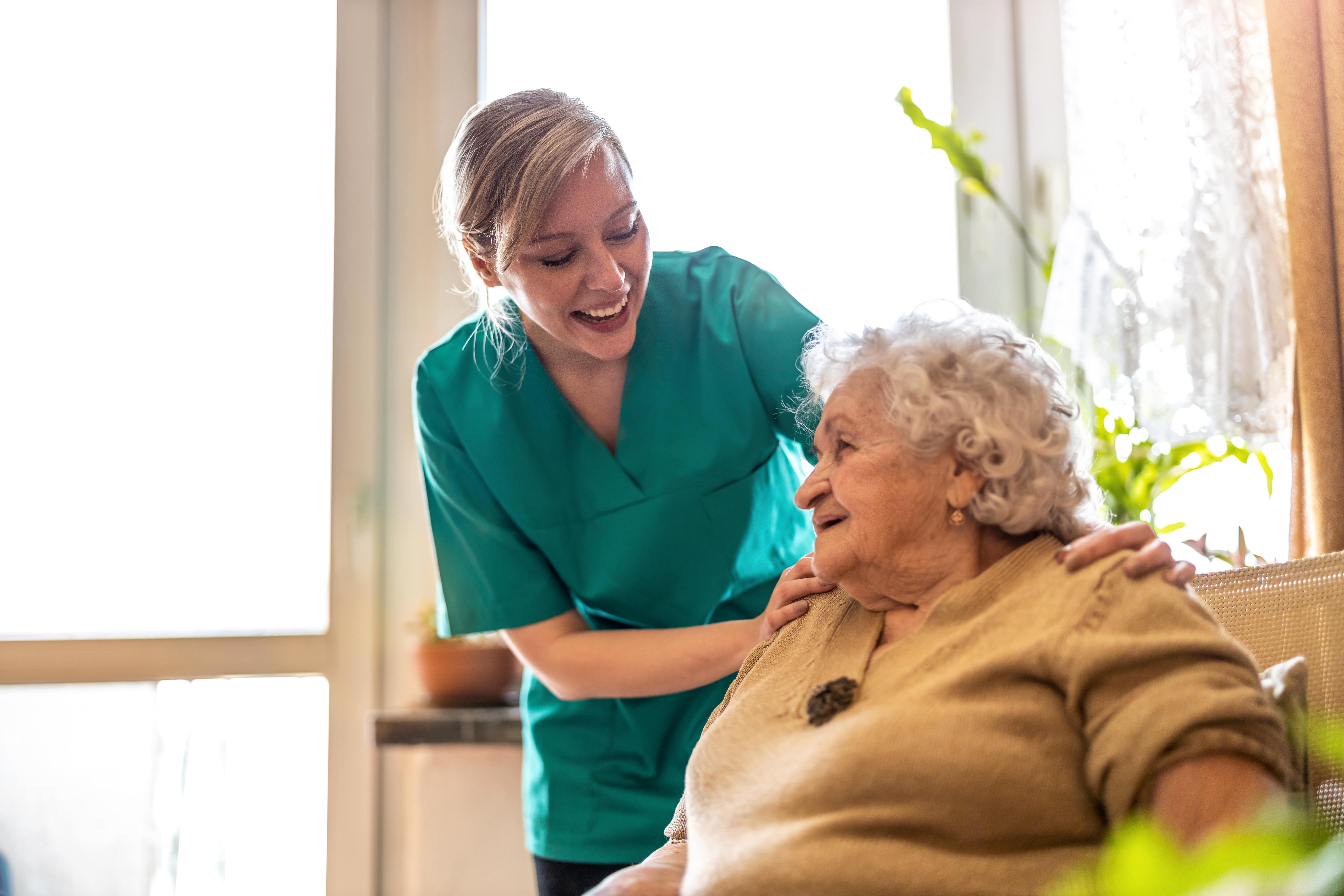 Friendly nurse supporting an elderly lady