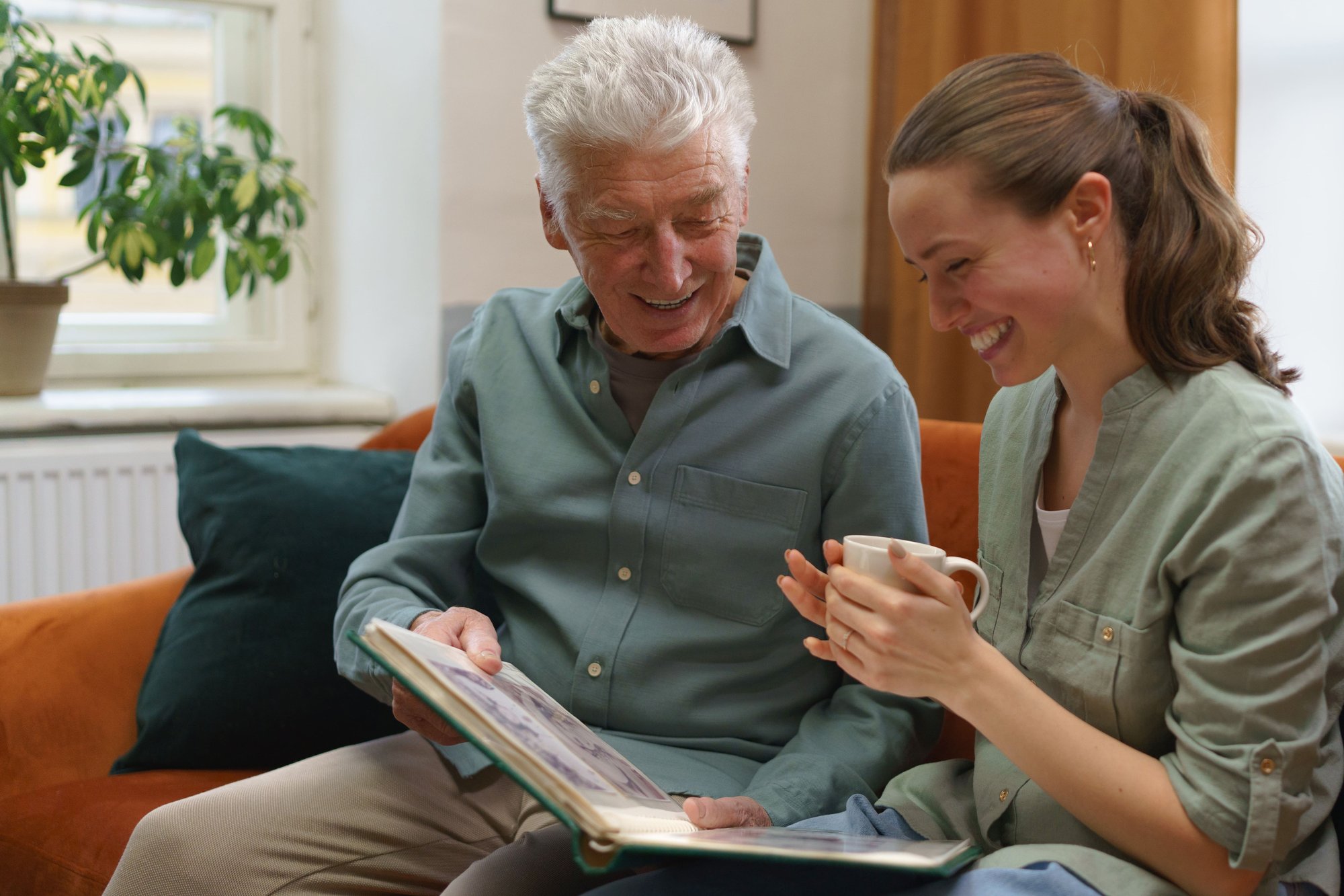 Older dad and daughter happily looking through a picture album