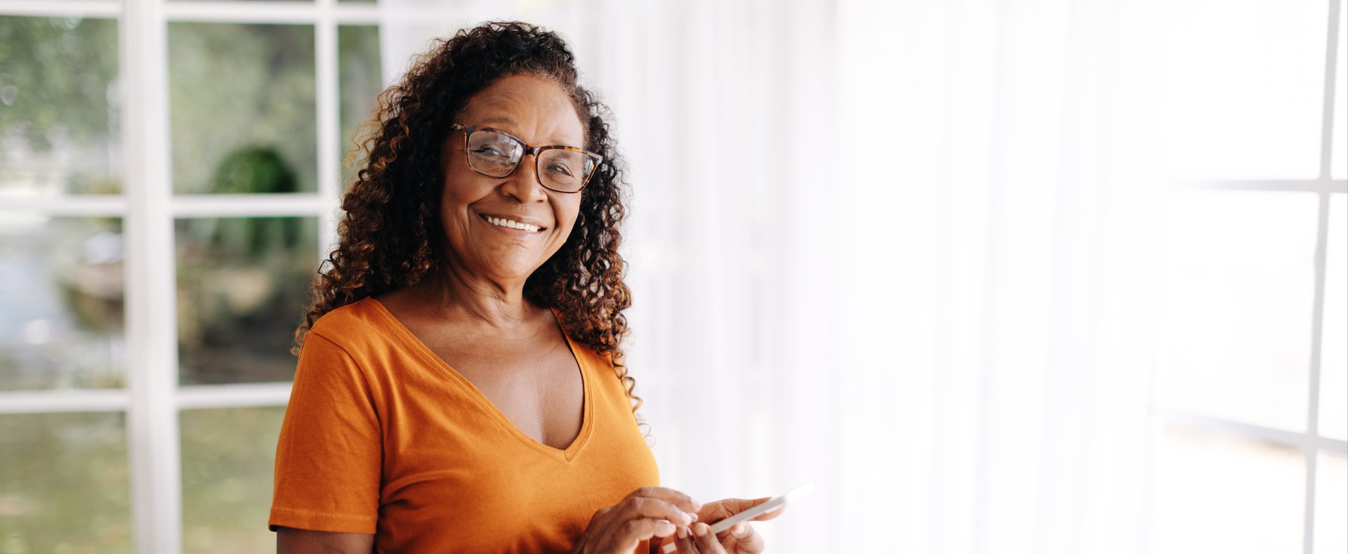 senior woman smiling with phone in hand