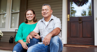 senior couple sitting on the front steps of a house