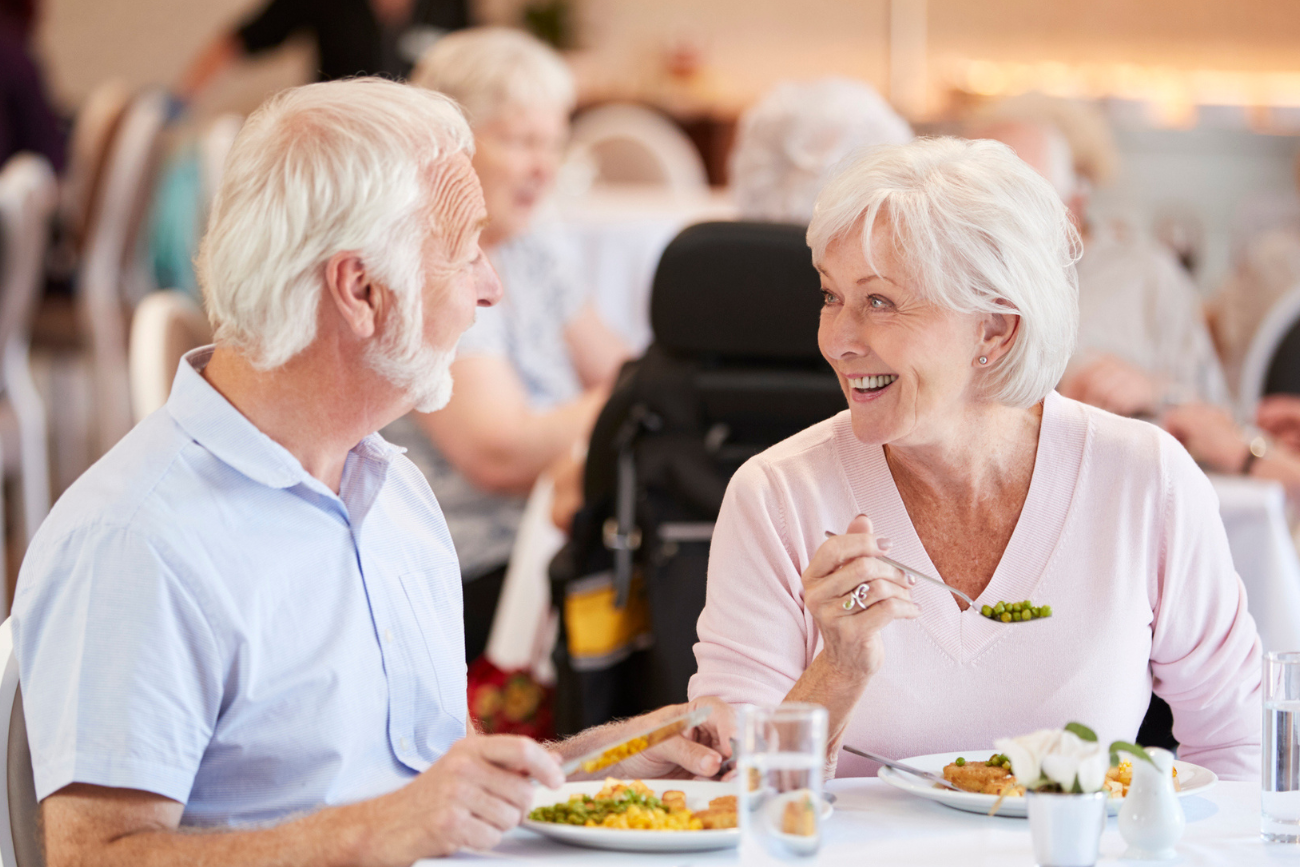 senior residents laughing at dinner