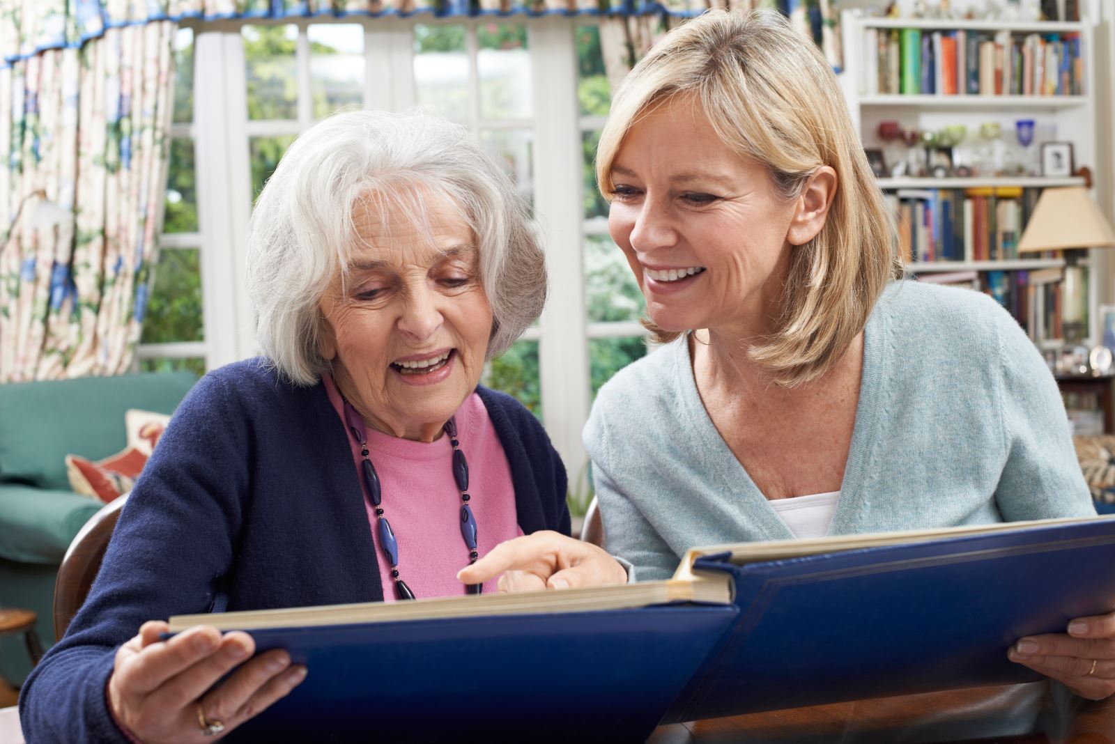 Daughter and older mom looking through a book