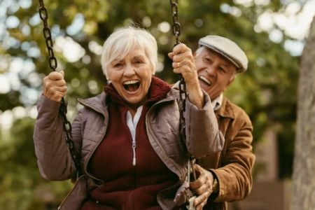 Senior couple having fun on a swing set